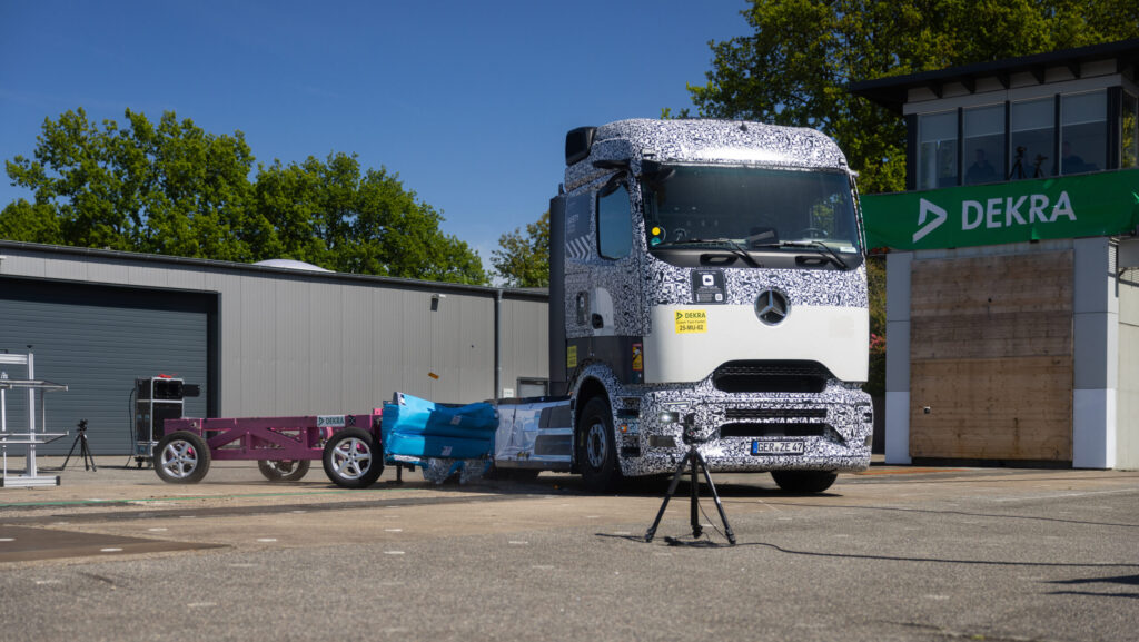 Ein Mercedes-Benz eActros 600 während eines seitlichen Crash-Tests auf dem DEKRA-Testgelände in Neumünster. Das Testfahrzeug wird von einer Aufprallvorrichtung getroffen.